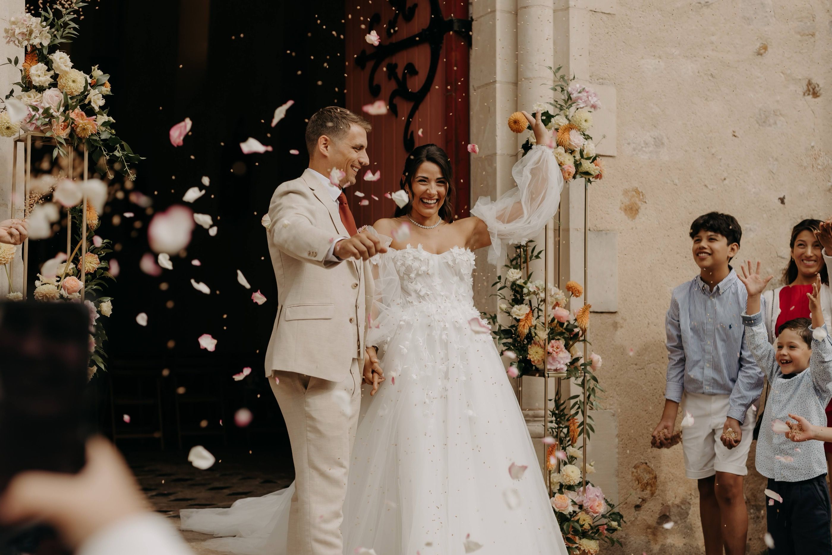 Les mariés sortent de l’église sous une pluie de confettis, entourés de leurs invités